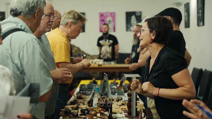 Interested visitors selecting and examining handmade pipes
